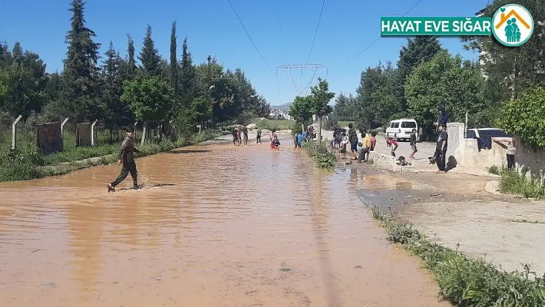 Çocukların patlayan borudan akan suda çamurla oyunu