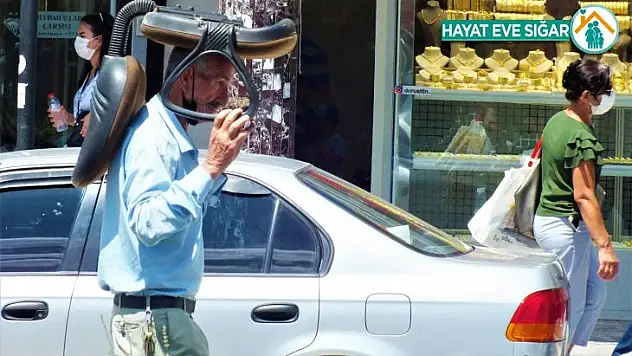 Sıcaktan korunmak isteyen vatandaştan ilginç yöntem: Kafasının üstünde koltukla yürüdü