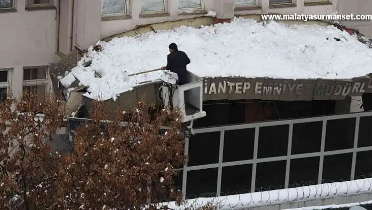 Emniyet müdürlüğünün kapı girişi çatısına düşen kar kütleleri vinç yardımıyla temizleniyor